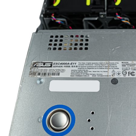 Close-up of server lid label and release button with cooling fans visible behind.