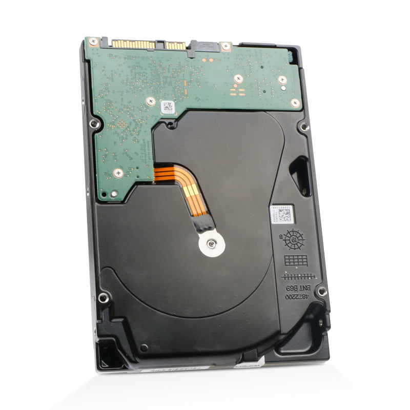 A close-up view of the underside of a standard 3.5-inch internal hard drive, showcasing its black metallic casing and key electronic components. A L-shaped green printed circuit board (PCB) is mounted at the top, featuring visible gold-plated connector pins for data and power. An orange four-lane ribbon cable extends from the PCB to the circular metal spindle motor at the drive's center. Technical markings, including a small QR code and molded text, are visible on the lower half of the black housing.