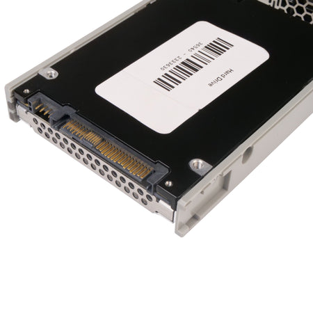 Underside of a enterprise SAS hard drive showing gold-plated connector pins and a white identification label with a barcode, secured in a server caddy.