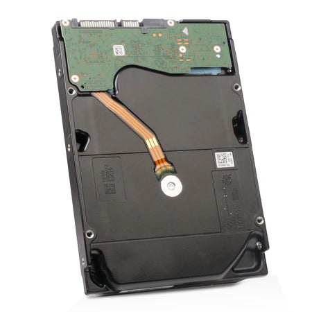 The bottom view of a Seagate enterprise-class hard drive, featuring a SATA interface, green PCB with multiple surface-mount components, and laser-etched identifying numbers and QR codes on the black metal chassis.