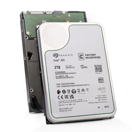Two Seagate Exos X22 hard drives stacked. The front drive label identifies it as a factory recertified 2TB SATA model (ST2000NM000E) with 7200 RPM and a DOM of Dec 2024