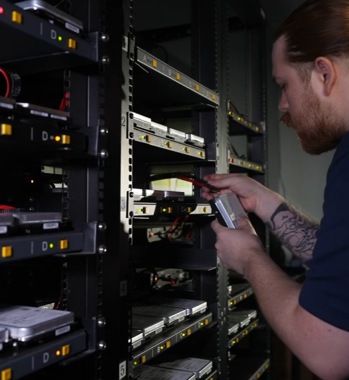A ServerPartDeals technician working on a populated server rack